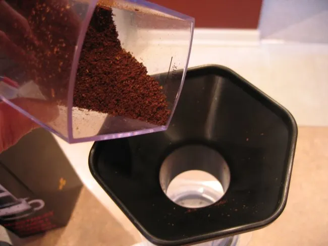 add coffee grounds into aeropress coffee brewer with funnel