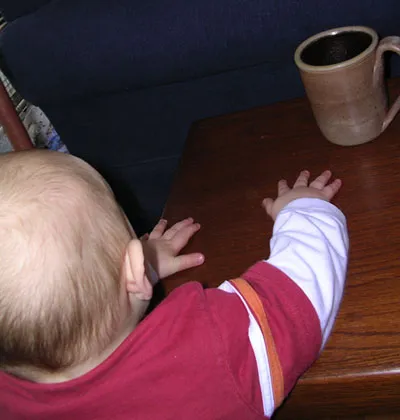 baby reaching for coffee mug